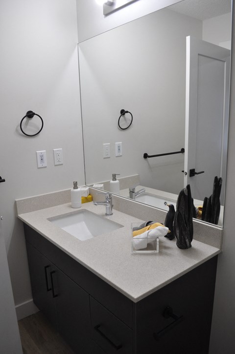 A bathroom with a sink and mirror at The Laurent at Laurel Apartments, Edmonton, AB